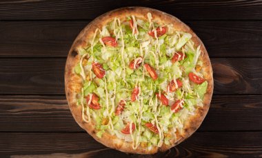 Beyaz soslu, tavuklu, parmesanlı, kiraz domatesli ve ahşap arka planda taze marullu pizza. Restoran pizzacısı menüsü kavramı