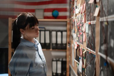 Bayan dedektif soruşturma kuruluna dikkatle bakıyor. Boşluğu kopyala