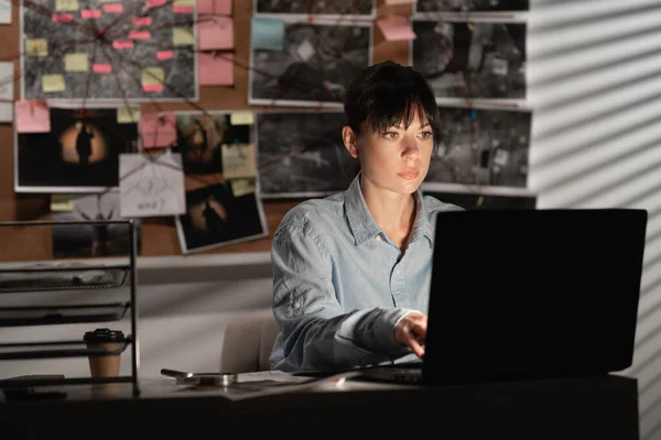 Detective processing evidence in her office using a laptop. copy space