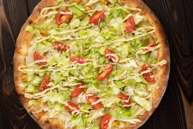 Tavuklu pizza Sezar ahşap arka planda, üst manzara, yakın plan.