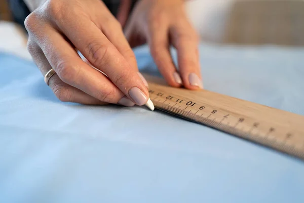 Ruce Krejčího Bílou Křídou Pravítkem Při Kreslení Detailů Světlou Tkaninu — Stock fotografie