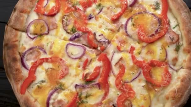サラミ コショウ 野菜のおいしいピザがテーブルの上で回転しているまな板の上に トップ表示 — ストック動画