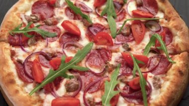 Eski ahşap masada servis edilen sıcak pizza. Kapat.