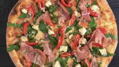 Jambonlu jambonlu pizza ve koyu ahşap arka planda parmesan peyniri. İtalyan mutfağı. Metin için boşluk.