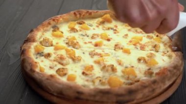 Tahta masada paten bıçağıyla taze pizza dilimlemek. Boşluğu kopyala
