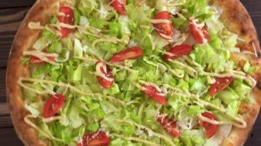 Tavuklu pizza Sezar ahşap arka planda, üst manzara, yakın plan.