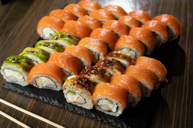 Suşi restoranda Japon yemeği yapar. Philadelphia suşi seti, somon, karides, sebze, yılan balığı ve havyar. Japon restoran menüsü konsepti