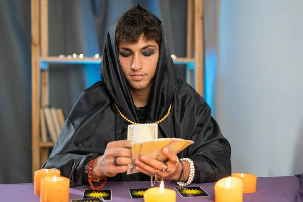 fortune teller man reading tarot cards on a table with candles. Copy space