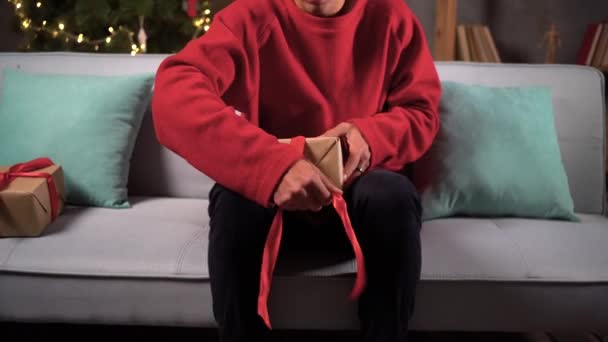 Santa Pria Mengemasi Kotak Dengan Hadiah Mengikat Pita Merah Duduk — Stok Video