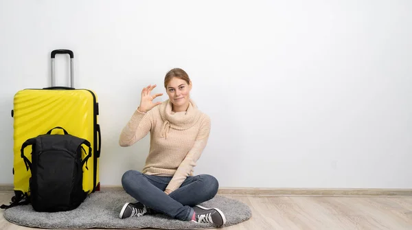 여행하는 여자는 가방을 가볍게 미소를 배경에 손가락을 몸짓을 승객은 해외로 — 스톡 사진