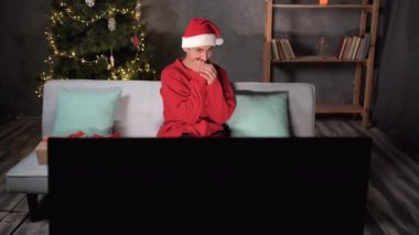 Noel Baba şapkalı genç adam geceleri korku filmi seyrediyor. Korkunç bir hikaye izliyor. Oturma odasındaki kanepede oturmaktan korkuyor ve şoka uğruyor.