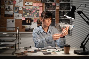 Dedektif ofisinde kanıtlarla çalışıyor. Boşluğu kopyala