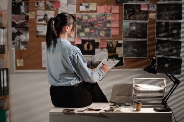 Dedektif, kanıt panosuna dikkatlice bakıyor. Boşluğu kopyala