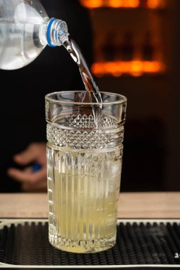 Barmen güzel bir gecede bardağa su dolduruyor. Boşluğu kopyala