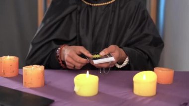 Falcı adam çevrimiçi bir oturum yaparken dizüstü bilgisayarın önünde tarot kartları düzenliyor. Modern teknoloji. Kapat.