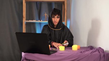 Tarot kartlarında kehanet oturumu. Tarot kartları okuyan bir falcı bilgisayar kullanarak geleceği tahmin eder. Öngörü kavramı