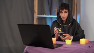 Falcı bilgisayarla tarot kartlarıyla geleceği okuyor. Çevrimiçi kehanet kavramı.