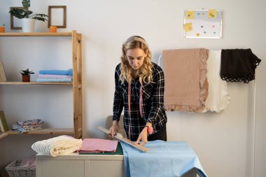designer at work with fabric. Tailor measuring necessary amount of material for sewing cloth. tailoring process, pattern cutting concept