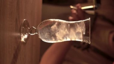 Barmen barın üzerine bardağa güçlü alkollü içecekler döküyor. Gece kulübünde Kokteyl Mavi Göl. Barmen gece kulübünde mavi kokteyl hazırlıyor. dikey video