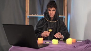 Tarot kartlarından kehanet. Tarot kartını okuyan bir erkek falcı video aramasıyla geleceği tahmin ediyor. Yeni iş konsepti