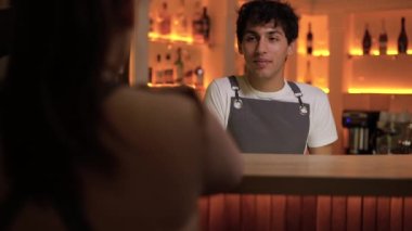 Barda konuşan gülümseyen barmen ve kadın ziyaretçi