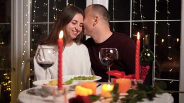 Romantik akşam yemeği, gözlüklü kırmızı şarap ve mumlar, iki kişilik randevu, Sevgililer Günü akşamı, masada mum yakma, yakın çekim.