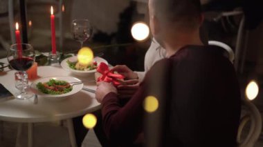 Aşık adam yemekte kız arkadaşına hediye verir. Kutuyu hediyeyle açan mutlu genç bir kadın, sevgilisine sevgiyle bakıyor, hediyesini alıyor. Milenyum çifti romantik vakit geçiriyor. Sevgililer Günü 'nü kutluyoruz.