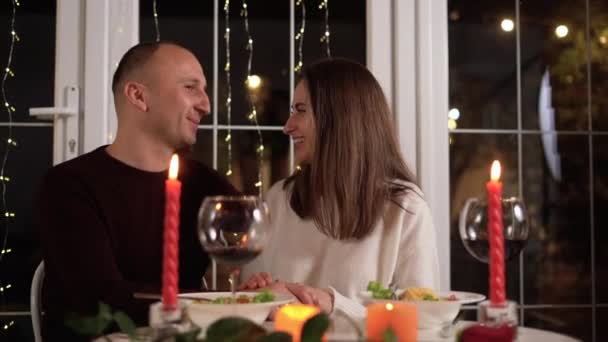 恋爱中的快乐夫妻在餐馆庆祝情人节 他们与蜡烛约会 坐在浪漫的餐桌前 戴着红葡萄酒 亲密接触 二月的情人节庆祝活动 — 图库视频影像