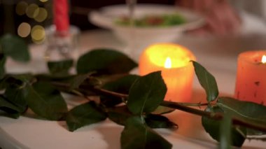 Romantik akşam yemeği gülleri ve mumlar kırmızı bir kutuda evlilik teklifi yüzüğü, yakın plan..