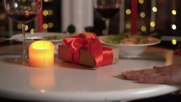 可爱的一对情侣欢度情人节 在浪漫的晚餐中亲切地牵着手 亲密地在一起 红色的礼物 蜡烛和红酒 庆祝二月十四日的概念 — 图库视频影像