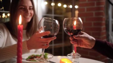 Çift evde romantik bir akşam yemeği yiyor, Sevgililer Günü 'nü restoranda kutluyor, aşıklar kırmızı şarap içiyor, yakın çekim yapıyor.