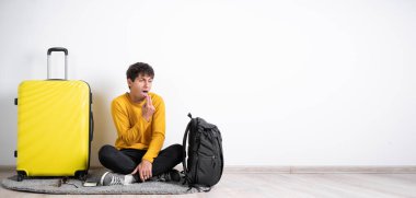 Elinde bavulu olan genç bir gezgin kusmak üzere olan parmaklarını ağzına sokuyor. Bu durumdan iğrendiğini gösteriyor. Berbat bir şey. İnsan yüzü ifadesi duygu tepkisi