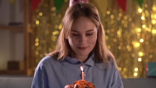 長い髪の女性の笑顔は彼女の誕生日ケーキにろうそくを吹く お祝い パーティー 誕生日のコンセプト — ストック動画