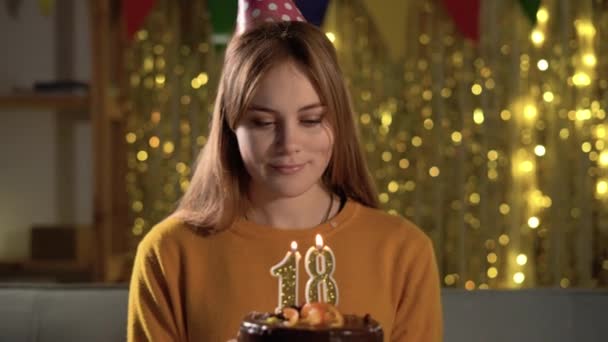 18歳の誕生日 誕生日ケーキにろうそく18を吹く若い女性 おいしいケーキを持ちながら願い事をする女の子 — ストック動画