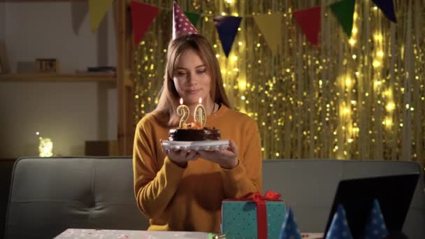 20歳の誕生日 誕生日ケーキにろうそくを吹く若い女性 20周年記念番号 おいしいケーキを持ちながら願い事をする女の子 — ストック動画