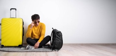 Beyaz arka planda güneş gözlüğü ve süveter takan genç Arap turist tek parmakla kafasını göstererek gülümsüyor, harika bir fikir ya da düşünce, iyi bir hafıza. Boşluğu kopyala