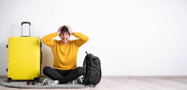 Kızgın gezgin bavuluyla çığlık atıyor ve elleri tedirgin bir şekilde beyaz arka planda bekliyor. Boşluğu kopyala