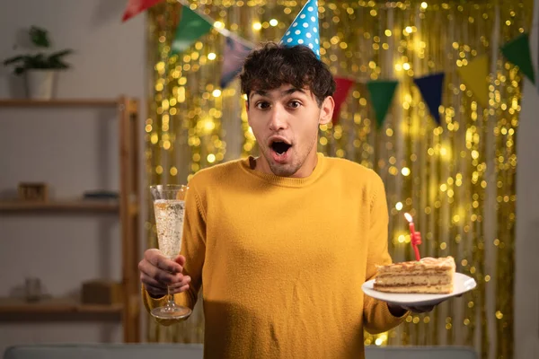 Arabic man celebrities to birthday, invites many friends for this special occasion, has shocked expression. Birthday man with cake and champagne being surprised to see girlfriend on party at his home