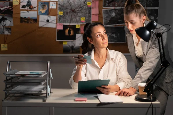 Two female detective working at desk in her office. Copy space