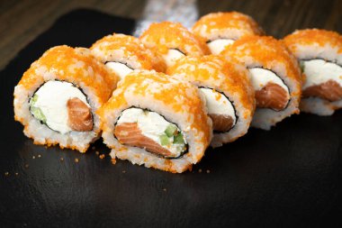 Somon, avokado ve krem peynirli taze ve lezzetli suşi rulosu. Suşi menüsü. Japon yemekleri konsepti.