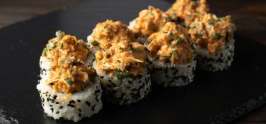 Lezzetli taze suşi, midye, salatalık, somon ve siyah susam tohumlu siyah kayrak taşı. Pankart