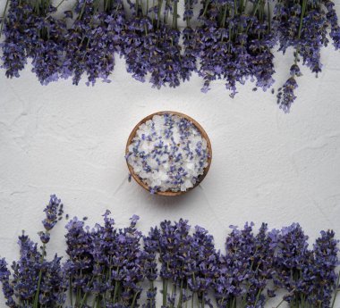 Doğal sabun, lavanta, beyaz beton arka planda tuz, banyo ve spa için hijyen malzemeleri. Düz yerde, üst tarafta. Boşluğu kopyala