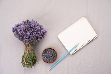 Alternatif tıp ve lavanta tariflerini tasvir etmek için lavanta çiçekleri, kağıt not defterleri ve objelerin fotoğrafının hemen üstünde. Metnini gazetelere ekle. Boşluğu kopyala