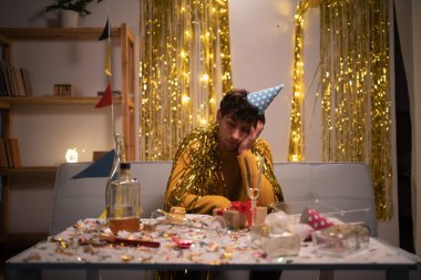 Evde kanepede oturan yorgun ve sarhoş bir adam. Boşluğu kopyala