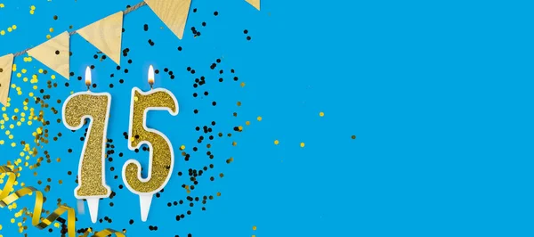 Golden candle number seventy five. Birthday or anniversary card with the inscription 75 on blue background. Anniversary celebration. Banner. copy space