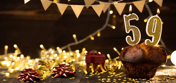 Number 59 golden festive burning candles in a cake, wooden holiday background. fifty nine years since the birth. the concept of celebrating a birthday, anniversary, holiday. Banner. copy space