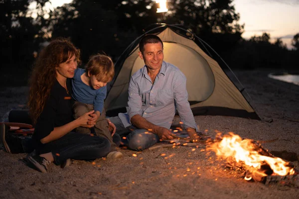 Happy family at camping with campfire at night. Camping, travel, tourism, hike and people concept