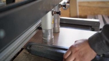 close-up of a drilling machine makes a hole in a wooden slab or chipboard. The process of production and manufacture of wooden furniture in a factory and woodworking industry