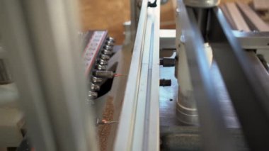 close-up of a drilling machine makes a hole in a wooden slab or chipboard. The process of production and manufacture of wooden furniture in a factory and woodworking industry