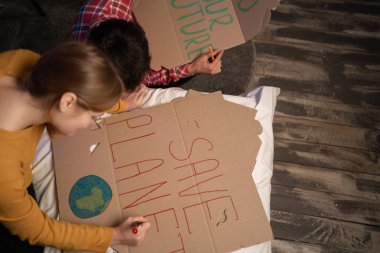 Students friends making placards for protest against climate change and for save planet. Copy space